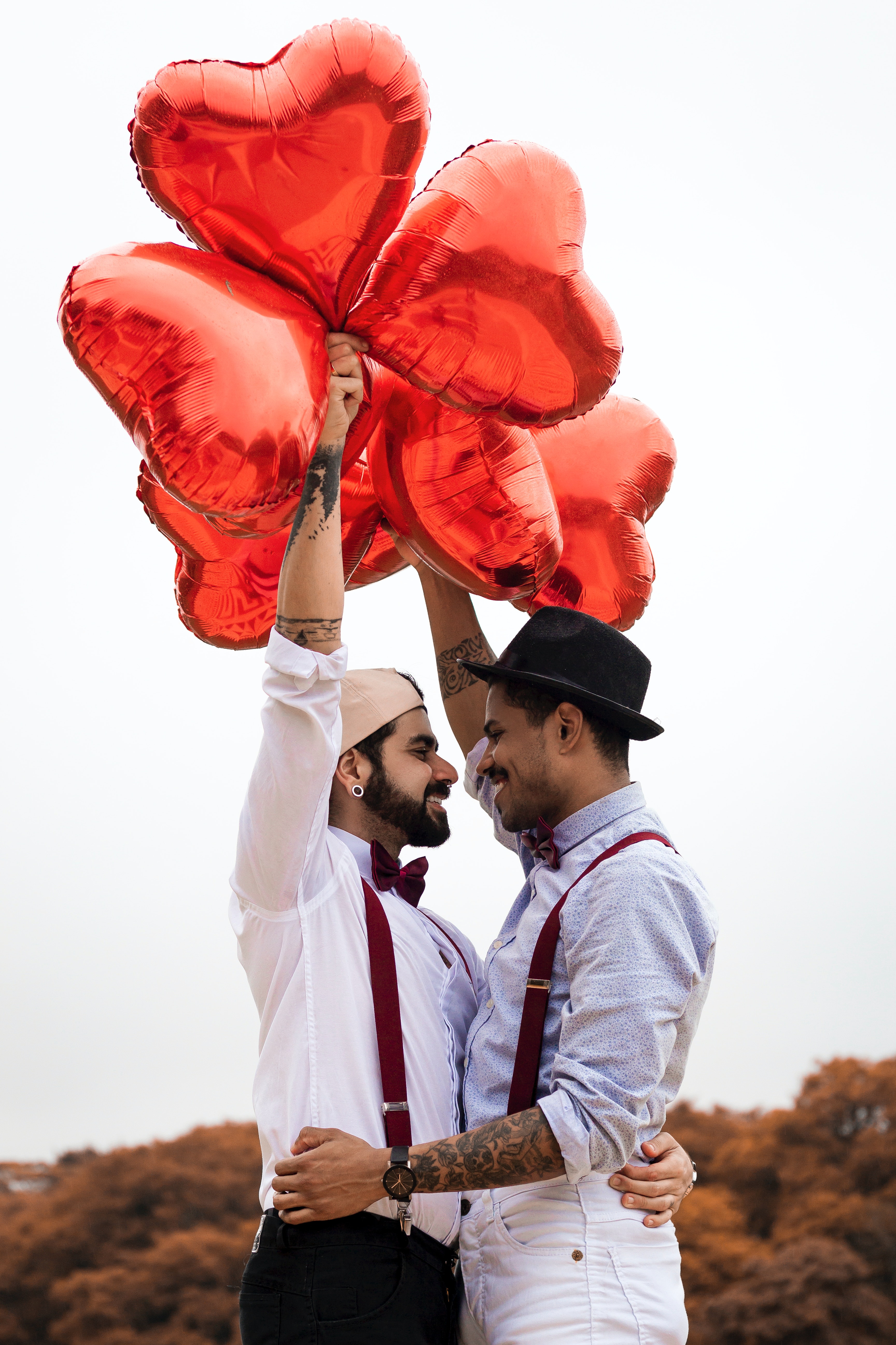 Homosexual couple with red heart balloons